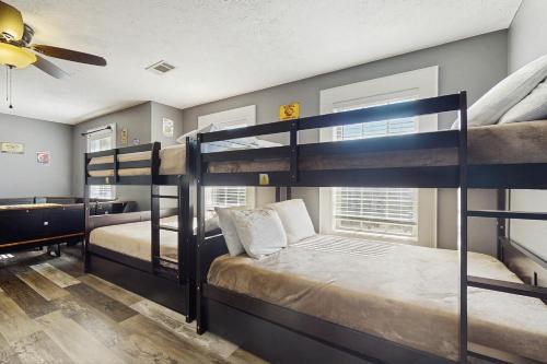 two bunk beds in a room with a ceiling fan at Hatters Hide A Way in Kodak
