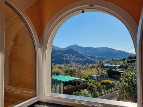 an arched window with a view of mountains at villino indipendente eden levanto in Levanto