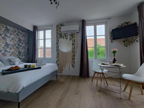 una camera da letto con un letto e un tavolo e un tavolo di Studio Kamelia a Saint-Aignan