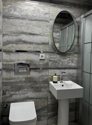 a bathroom with a sink and a toilet and a mirror at Invivo Hotel in İzmir