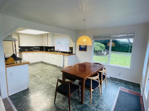 a kitchen with a wooden table and some chairs at Surfside Beach House near Ancient Redwoods in Smith River