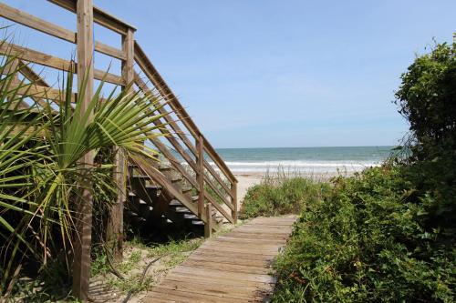 einen Holzweg, der zum Strand mit dem Meer führt in der Unterkunft Oceanfront Nest Down in Folly Beach