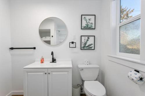 a white bathroom with a toilet and a mirror at Breakwater Resort in Grayland