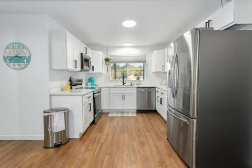 a kitchen with white cabinets and a stainless steel refrigerator at Breakwater Resort in Grayland