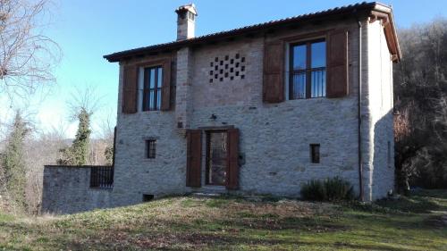 an old stone house on top of a hill at Borgo Pizzicarè in Vado