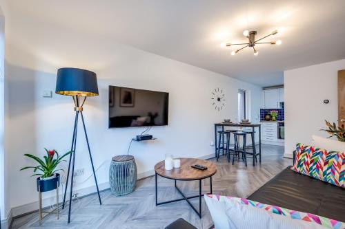 a living room with a couch and a table at Stylish Belfast City Centre Apartment in Belfast