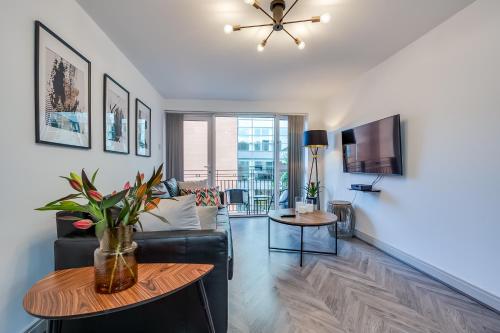 a living room with a couch and a table at Stylish Belfast City Centre Apartment in Belfast