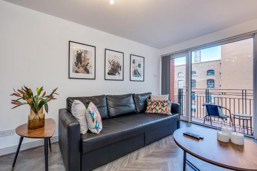 a living room with a couch and a table at Stylish Belfast City Centre Apartment in Belfast