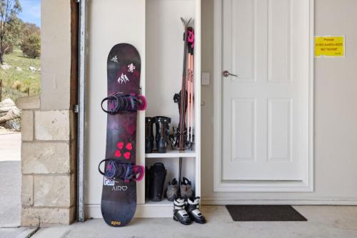 two snowboards are leaned against a wall next to a door at Whistler 1 in Jindabyne
