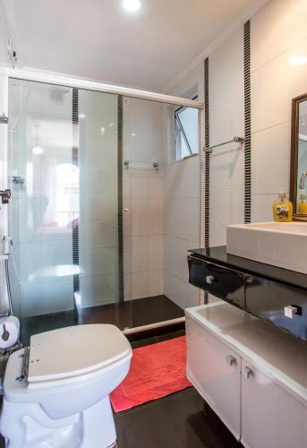 a bathroom with a white toilet and a sink at Cobertura com piscina privativa próxima à praia in Cabo Frio