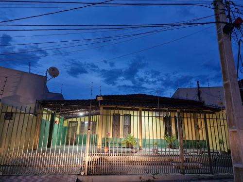 an old house with a fence in front of it at Apto próx ao Shopping in Rondonópolis