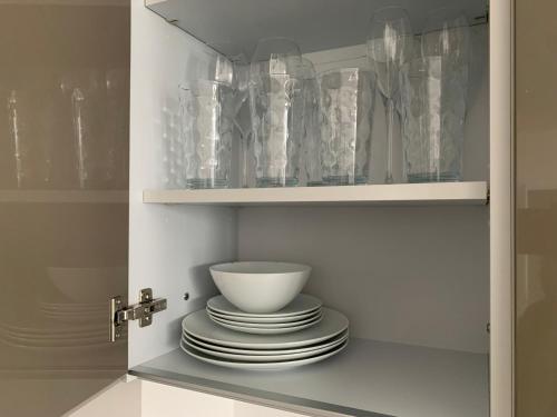 a cabinet filled with plates and glass vases at Lovely 1Bed flat 10mins to Canary Wharf & parking in Woolwich