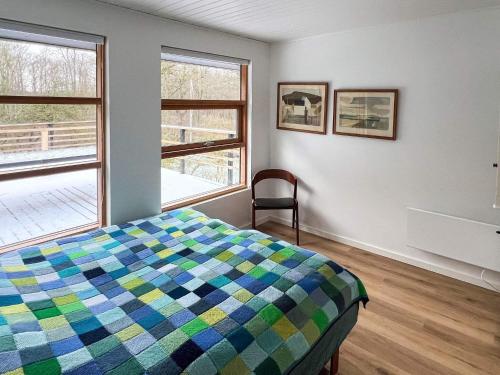 a bedroom with a colorful bed and two windows at 6 person holiday home in Asperup in Asperup