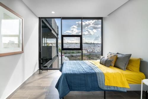 a bedroom with a yellow bed and a large window at Departamento moderno en zona norte in Laurel de Lagunillas