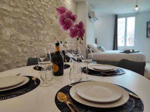 - une table avec des assiettes, des verres et une bouteille de vin dans l'établissement Studio Kamelia, à Saint-Aignan