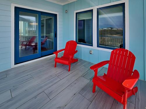 two red chairs on the porch of a house at Dune Our Thing North Topsail Beach in North Topsail Beach