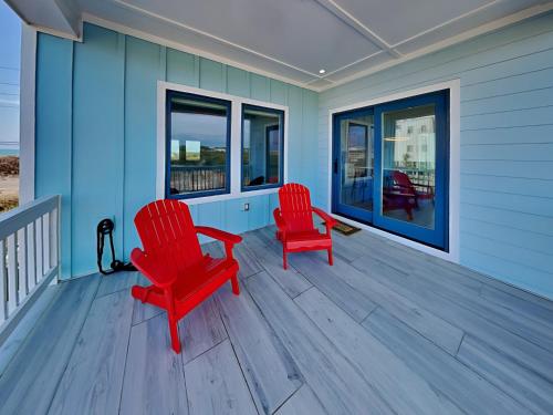 two red chairs on the porch of a house at Dune Our Thing North Topsail Beach in North Topsail Beach
