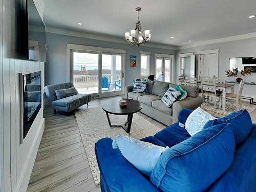 a living room with a blue couch and a tv at Dune Our Thing North Topsail Beach in North Topsail Beach