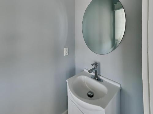 a white bathroom with a sink and a mirror at Dune Our Thing North Topsail Beach in North Topsail Beach