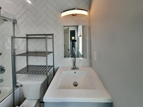 a bathroom with a sink and a toilet and a mirror at Dune Our Thing North Topsail Beach in North Topsail Beach