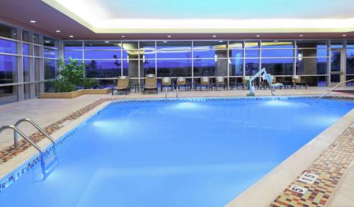 a large swimming pool in a hotel at night at Embassy Suites Loveland Conference Center in Loveland