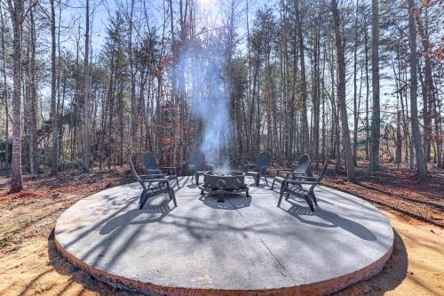 a fire pit with four chairs and a table with smoke at 12 Mi to Tryon International Forest City Gem! in Forest City
