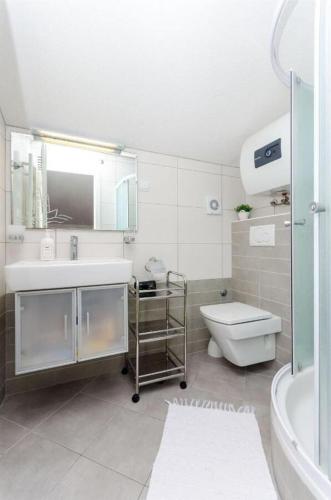 a bathroom with a sink and a toilet and a shower at Apartments Jasna in Baška Voda
