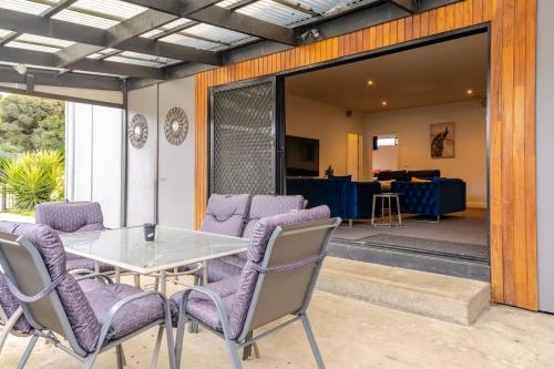 a patio with a table and chairs and a living room at Huge 4BR Pool Table & 75" TV in Ballarat