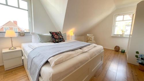 ein großes Bett in einem Zimmer mit einem großen Fenster in der Unterkunft Haus Eversand 2 in Cuxhaven