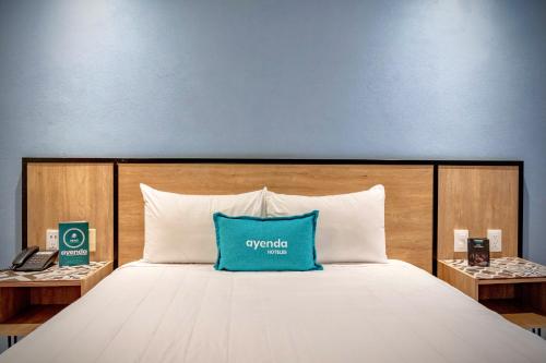 a bed with a blue pillow on top of it at Continental Mexicano in Mexico City