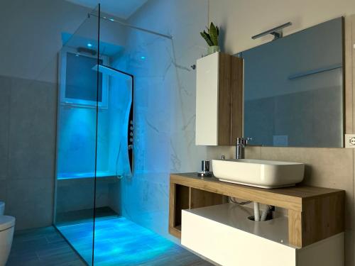 a bathroom with a sink and a glass shower at La Vetere House in Catania