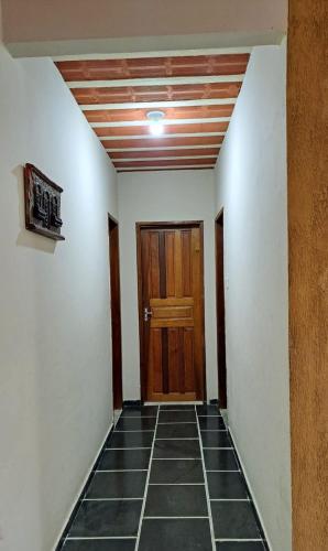 a hallway with a wooden door and a tile floor at Casa Costa Verde-Muriqui in Vila Muriqui