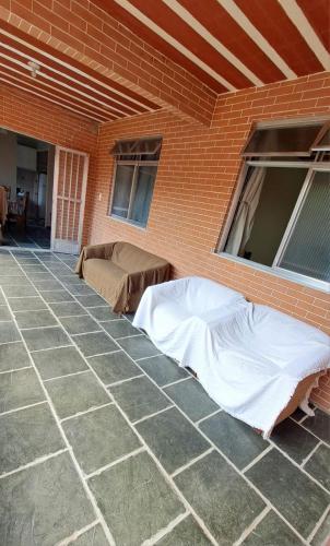 a patio with two beds and a brick wall at Casa Costa Verde-Muriqui in Vila Muriqui