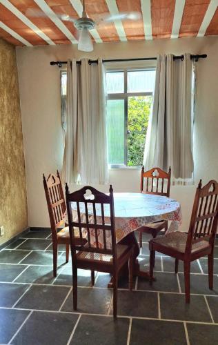 a dining room with a table and chairs and a window at Casa Costa Verde-Muriqui in Vila Muriqui
