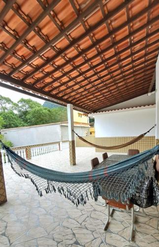 a hammock on a patio with a roof at Casa Costa Verde-Muriqui in Vila Muriqui