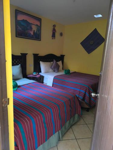 two beds in a hotel room with two at Casa Francisco's in Antigua Guatemala