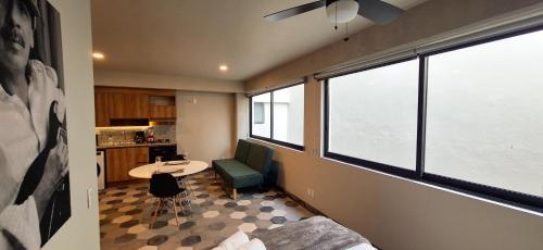a room with a couch and a table and windows at Casa 8 in Guadalajara