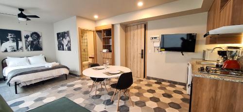 a room with a bed and a table and a kitchen at Casa 8 in Guadalajara