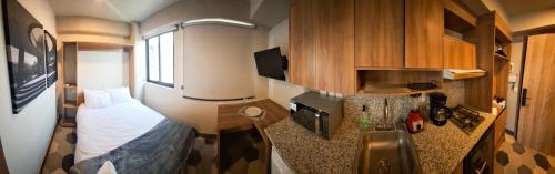 a small room with a bed and a kitchen at Casa 8 in Guadalajara