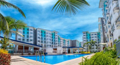 ダバオシティにあるVin's Cloud9 Queen Bed Netflix SMX-Davao Airport-Samal Ferryのスイミングプールとヤシの木があるリゾートの景色を望めます。