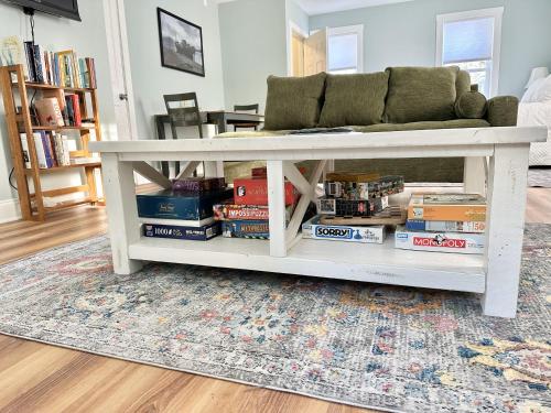 a living room with a couch and books on a rug at 2 BR Home in Bar Harbor Town Hill "Deer Run" in Bar Harbor