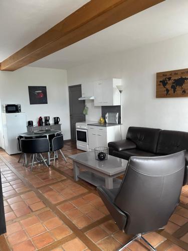 un salon avec un canapé et une cuisine dans l'établissement Gîte de l 'Angeline, à Bissey-sous-Cruchaud