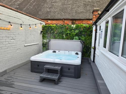 a bath tub sitting on a deck next to a building at Centre Apartment - Sleeps 2 & Roof Top Hot Tub in Derby