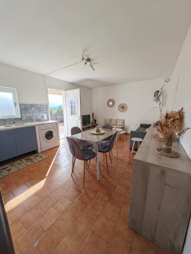 une cuisine et un salon avec une table et des chaises dans l'établissement F2 cosy idéal pour les vacances, à Sarrola-Carcopino
