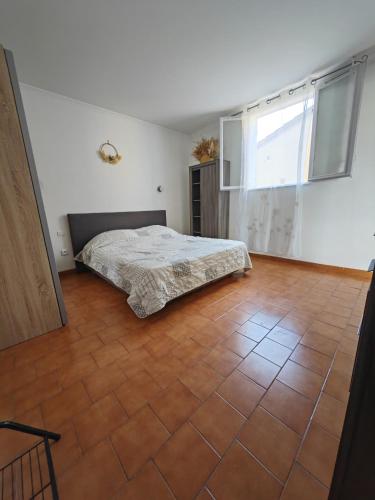 une chambre avec un lit et un sol carrelé dans l'établissement F2 cosy idéal pour les vacances, à Sarrola-Carcopino