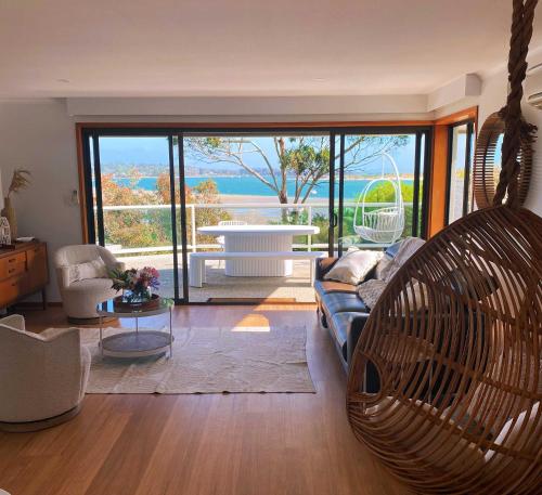 a living room with a couch and a swing at Seagrass Coastal Retreat with direct beach access in Lewisham