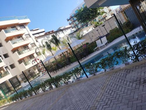 a fence next to a swimming pool in a city at Apartamento Carnaval Cabo Frio in Cabo Frio