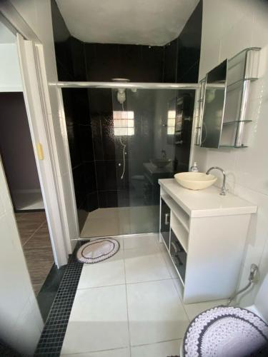 a small bathroom with a shower and a sink at La Melangerie - Hostel in Bertioga