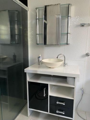 a bathroom with a sink and a shower at La Melangerie - Hostel in Bertioga