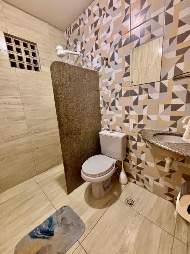 a bathroom with a toilet and a sink at 01 Apartamento Mandacaru in Caruaru